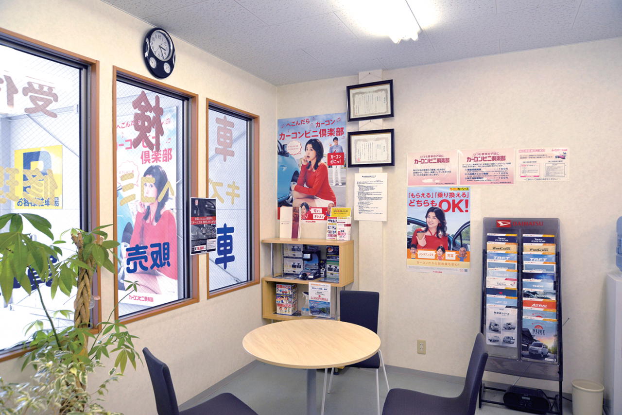 店舗の壁にたくさんのカーコンのポスターを貼って、カーコン店をアピール。「修理事例紹介」などにも積極的に取り組んでいます。